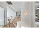 Bright hallway with hardwood floors, white railing, and decorative wall lighting, offering a modern and stylish transition between spaces at 1505 Rivertowne Country Club Dr, Mount Pleasant, SC 29466