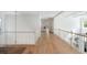 Spacious upper hallway with wood floors and white railings, offering a bright and open transition between rooms at 1505 Rivertowne Country Club Dr, Mount Pleasant, SC 29466