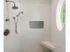 Bright white tiled shower features bronze fixtures, built-in seat and a circular window at 1505 Rivertowne Country Club Dr, Mount Pleasant, SC 29466