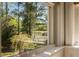 Picturesque view of a pond and golf course framed by lush greenery through a window at 1505 Rivertowne Country Club Dr, Mount Pleasant, SC 29466