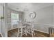 Bright dining area featuring a white table and chairs, wood floors and a modern light fixture at 1507 Blaze Ln, Charleston, SC 29412