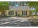 Charming one-story home featuring yellow siding, blue shutters, and a well-manicured lawn with mature trees at 1507 Blaze Ln, Charleston, SC 29412