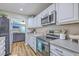 Eat-in kitchen featuring white cabinets, stainless steel appliances and view to living room at 1507 Blaze Ln, Charleston, SC 29412