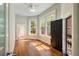 Bright room with hardwood floors, ceiling fan, and a view of the tree-lined street through windows at 17 Wentworth St, Charleston, SC 29401