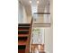Staircase with wood treads and white risers, leading to a landing with a view of the front door and transom window at 17 Wentworth St, Charleston, SC 29401