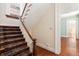 A view of a staircase with a carpet runner and a wooden railing with a view to another room at 17 Wentworth St, Charleston, SC 29401
