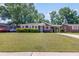 Charming single-story brick home with a well-manicured front lawn and mature trees at 1821 Wasp St, North Charleston, SC 29405