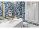 Stylish bathroom features patterned wallpaper, gold hardware, and a large mirror at 2 Pagett St, Daniel Island, SC 29492