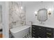 Luxurious bathroom with a soaking tub, marble tile, and modern vanity with gold accents at 2 Pagett St, Daniel Island, SC 29492