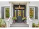 Elegant front entrance with black door, white columns, decorative lighting, and potted flowers at 2 Pagett St, Daniel Island, SC 29492