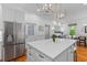 Contemporary kitchen with stainless steel refrigerator and a marble-topped island with bar seating at 2 Pagett St, Daniel Island, SC 29492