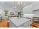 Bright kitchen with white cabinetry, stainless appliances, marble island, and hardwood floors at 2 Pagett St, Daniel Island, SC 29492