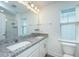 Bathroom features a double sink vanity with granite countertops and a framed mirror illuminated by a light fixture at 2009 E Patterson Pt, Hanahan, SC 29410