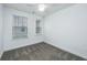 This minimalist bedroom features neutral walls, carpeted floor, a ceiling fan, and natural light from two windows at 2009 E Patterson Pt, Hanahan, SC 29410