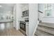 Modern kitchen featuring stainless steel appliances, granite countertops, and white cabinetry adjacent to carpeted stairs at 2009 E Patterson Pt, Hanahan, SC 29410