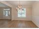 Beautiful dining room with wood floors, wainscoting, a chandelier, and a view of the front yard through the window at 208 Molasses Mill Ct, Summerville, SC 29485