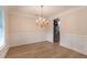 Elegant dining area featuring wainscoting, wood floors, a chandelier, and ample natural light from a window at 208 Molasses Mill Ct, Summerville, SC 29485