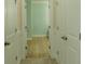 Hallway featuring hardwood floors, multiple doors, and neutral paint at 208 Molasses Mill Ct, Summerville, SC 29485