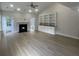Bright living room with light wood floors, fireplace, built-in shelves, and French doors at 208 Molasses Mill Ct, Summerville, SC 29485
