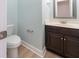 A neutral powder room with a dark vanity and mirror at 208 Molasses Mill Ct, Summerville, SC 29485