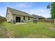 A spacious, grassy backyard featuring a patio, sliding glass doors, and partial fencing at 219 Whirlaway Dr, Moncks Corner, SC 29461