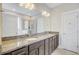 Bathroom featuring dual sinks with granite countertops, dark cabinets, and walk-in shower at 219 Whirlaway Dr, Moncks Corner, SC 29461