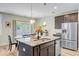 Open-concept kitchen with island, stainless appliances, and views into the dining area and backyard at 219 Whirlaway Dr, Moncks Corner, SC 29461