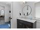 Well-lit bathroom with a sleek, dark vanity and modern fixtures, complemented by a round mirror at 221 Ashley Ave # Abc, Charleston, SC 29403