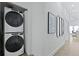 Hallway featuring a stacked washer and dryer, artwork, and doors leading to other areas of the home at 221 Ashley Ave # Abc, Charleston, SC 29403