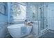 Serene bathroom featuring a soaking tub, separate glass shower, and window views at 23 Forde Row, Charleston, SC 29412