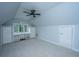 Light-filled attic bedroom features neutral carpet, vaulted ceilings, built-in desk and a ceiling fan at 23 Forde Row, Charleston, SC 29412