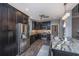 Modern kitchen with stainless steel appliances, dark cabinetry, granite countertops, and a stylish kitchen island at 23 Forde Row, Charleston, SC 29412