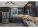 Bright kitchen showcasing stainless steel appliances, dark cabinets, and granite countertops with under cabinet lighting at 23 Forde Row, Charleston, SC 29412