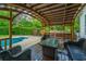 Covered outdoor seating area provides a relaxing view of the pool and lush backyard at 23 Forde Row, Charleston, SC 29412