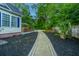 Side yard with brick walkway, manicured lawn, and access to a private backyard oasis at 23 Forde Row, Charleston, SC 29412