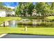 Scenic view of a community pond with a fountain, surrounded by green grass at 250 Grand Oaks Dr, Ladson, SC 29456