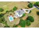 Aerial view of a luxurious home with a circular driveway, landscaped grounds, and private pool at 2636 Anchor Watch Dr, Wadmalaw Island, SC 29487