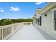 Over-sized balcony with white railings offering views of a lush green landscape and access to the house at 2636 Anchor Watch Dr, Wadmalaw Island, SC 29487