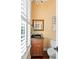 Charming powder room with dark vanity, wooden floors, and window with plantation shutters at 2636 Anchor Watch Dr, Wadmalaw Island, SC 29487