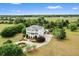 Stunning aerial view of a white two-story home featuring an elegant fountain and lush landscaping at 2636 Anchor Watch Dr, Wadmalaw Island, SC 29487