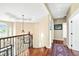 Upper hallway featuring hardwood floors, ornate lighting fixture, art niche and views of the foyer below at 2636 Anchor Watch Dr, Wadmalaw Island, SC 29487