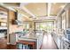 Spacious kitchen with a center island, custom cabinets, stainless appliances, brick backsplash, and hardwood floors at 2636 Anchor Watch Dr, Wadmalaw Island, SC 29487