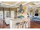 Modern kitchen featuring granite island, custom cabinets, stainless appliances, brick backsplash, and hardwood floors at 2636 Anchor Watch Dr, Wadmalaw Island, SC 29487