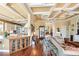 Open-concept living space with hardwood floors, coffered ceilings, and view of kitchen at 2636 Anchor Watch Dr, Wadmalaw Island, SC 29487