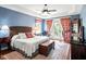 A charming main bedroom featuring blue walls, wood floors, ceiling fan and private access to the outdoor balcony at 2636 Anchor Watch Dr, Wadmalaw Island, SC 29487