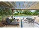 Lounge by the pool with a pergola-covered seating area that's perfect for entertaining at 2636 Anchor Watch Dr, Wadmalaw Island, SC 29487