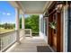 Inviting front porch with columns, a wooden door and black framed windows at 2636 Anchor Watch Dr, Wadmalaw Island, SC 29487