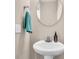 Bathroom featuring a pedestal sink, round mirror, and teal towel at 281 Jackson St, Goose Creek, SC 29445