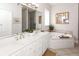 Bright bathroom with double sink vanity, soaking tub, and decorative wall mirror at 3013 Middle St, Sullivans Island, SC 29482