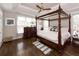 Bedroom with four-poster bed, decorative ceiling, hardwood floors, and lots of natural light at 3013 Middle St, Sullivans Island, SC 29482
